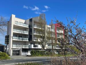 un edificio de apartamentos con un aparcamiento enfrente en Le Lodge Park à La Rochelle en La Rochelle