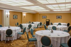 uma sala de conferências com mesas e cadeiras brancas em Sheraton Pentagon City em Arlington