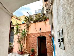 un callejón con un edificio de ladrillo con plantas. en Casa vacanze Hippocampus, en Salerno