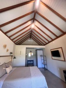 Chalé Rosa Serena في إيمبيتوبا: غرفة نوم بسرير كبير وسقوف خشبية