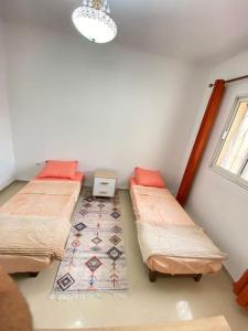 Cette chambre comprend 2 lits et une fenêtre. dans l'établissement Spacious Cozy Appartment Akid Lotfi ORAN, à Oran