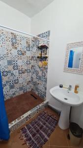 La salle de bains est pourvue d'un lavabo blanc et d'un miroir. dans l'établissement Spacious Cozy Appartment Akid Lotfi ORAN, à Oran