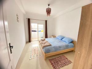 Habitación pequeña con cama y ventana en Spacious Cozy Appartment Akid Lotfi ORAN, en Orán