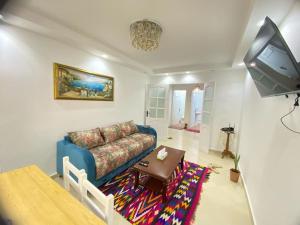 - un salon avec un canapé bleu et une table dans l'établissement Spacious Cozy Appartment Akid Lotfi ORAN, à Oran