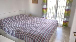 a bedroom with a bed with a striped cover on it at Calanuza in El Campello +19 photos