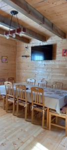 a dining room with a long table and chairs at Wooden house Nada (Drvena kuća Nada) in Zaovine