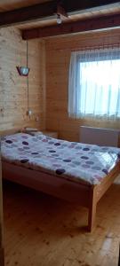 a large bed in a room with a window at Wooden house Nada (Drvena kuća Nada) in Zaovine