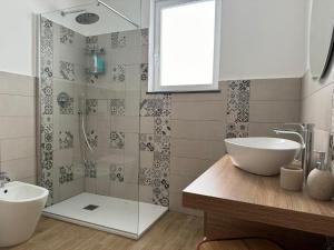 een badkamer met een wastafel en een douche bij Za Nedda Home in Fiumefreddo di Sicilia