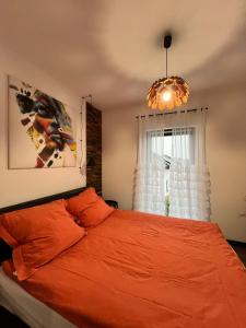 a bedroom with an orange bed and a window at Silesia Apartments B129 in Ustroń