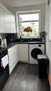a kitchen with white cabinets and a sink and a window at Ur Place 204 in Manchester
