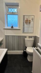 baño con aseo blanco y ventana en Ur Place 204 en Mánchester