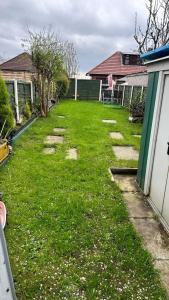 a yard with rocks in the grass next to a house at Ur Place 204 in Manchester