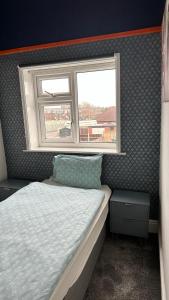 a small bedroom with a bed and a window at Ur Place 204 in Manchester