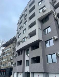 a tall grey building with balconies on it at Teddy Apartment in Veliko Tŭrnovo