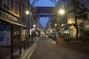 a city street at night with street signs and buildings at Cosy Studio in Nogent-sur-Marne, City Centre, WiFi in Nogent-sur-Marne