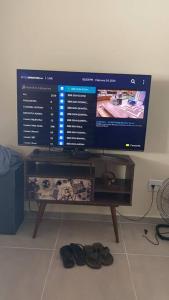 a flat screen tv sitting on a table with shoes at Chácara Mahalo’s in Sorocaba