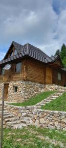 a house on top of a stone wall at Wooden house Nada (Drvena kuća Nada) in Zaovine