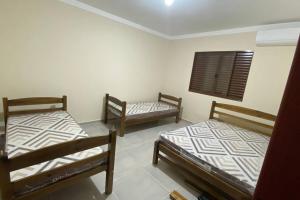 um quarto com três camas num quarto em Chácara Mahalo’s em Sorocaba