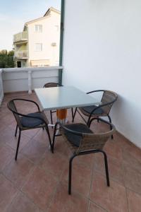 une table et des chaises assises sur un balcon dans l'établissement Tolle Ferienwohnung in Privlaka mit Terrasse, Grill und Garten, à Privlaka