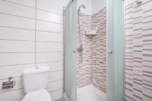 a white bathroom with a shower and a toilet at City Life Marina apartment No. 15 in Ampavris