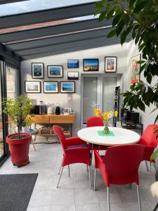a living room with a table and red chairs at La Maison Angèle in Caisnes