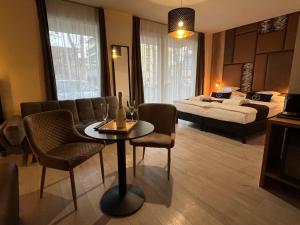 sala de estar con cama, mesa y sillas en Baobab Suites en Siófok