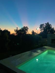 una piscina con tramonto sullo sfondo di Domus otello a Casarano