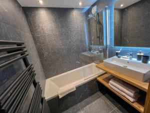a bathroom with a sink and a bath tub at Cabana & L Altima Megeve Piscine Saune Hamman disponible à partir de mi-juillet in Megève