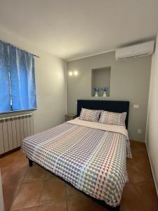 - une chambre avec un lit et une couverture en damier dans l'établissement Appartamento Da.Flo, à Gallarate