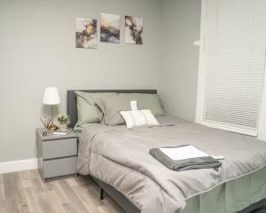 een slaapkamer met een bed en een nachtkastje met een lamp bij Cozy apartment in Irvington. in Irvington