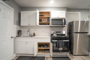 a kitchen with white cabinets and a stainless steel refrigerator at Cozy apartment in Irvington. in Irvington
