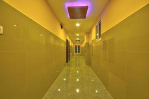 um corredor vazio com uma luz roxa no tecto em Collection O Joliday Inn em Mahabalipuram