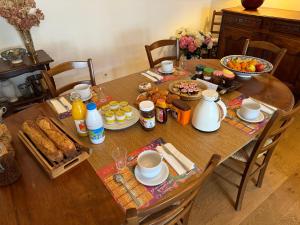 una mesa de madera con productos para el desayuno en les crépinières, en Chartres