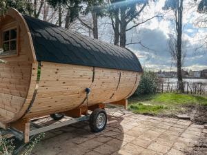 a wooden boat on a trailer with a roof at Das Wiesenhaus Wohnen im Schlaffass in Cologne