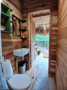 a bathroom with a toilet and a sink in a cabin at Casa Sol Y Sombra in Santa Marta