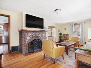 a living room with a fireplace with a tv above it at The cottage by the lake in Lakewood