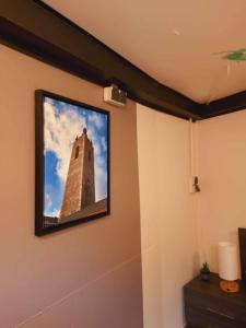 a television hanging on a wall with a tower at Gîte Le Sambre in Thuin