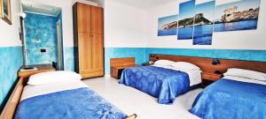 ein Hotelzimmer mit 2 Betten in einem Zimmer in der Unterkunft Hotel Blu Eden in Praia a Mare
