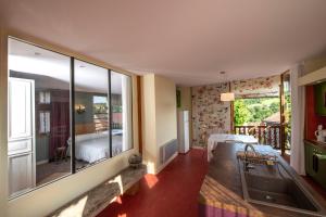 a room with a large window and a bedroom with a bed at Chambre d'Hôtes et gites du Tapissier in Polignac