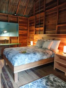 1 dormitorio con 1 cama y pared de madera en Casa Sol Y Sombra, en Santa Marta