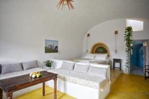 uma sala de estar com um sofá branco e uma mesa em Sunlight Cave Agrilia em Therasia