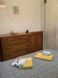 - une chambre avec une commode et 2 serviettes sur un lit dans l'établissement La croisière, à Étretat