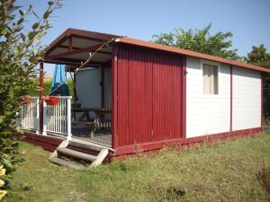 cobertizo rojo y blanco con porche en Belles vacances aux chalets en Casteljaloux