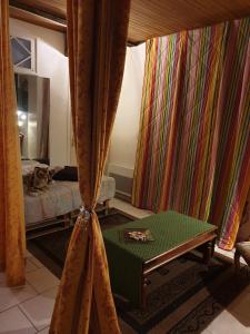 a room with a bed and a table and curtains at La Demeure in Gabarret