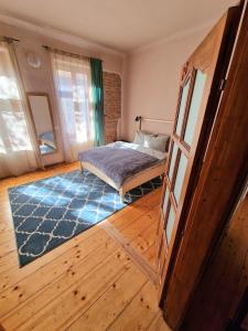 1 dormitorio con 1 cama y suelo de madera en World Studio Family Apartment, en Sibiu
