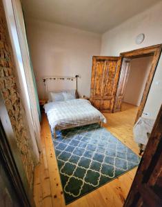 1 dormitorio con cama y alfombra azul en World Studio Family Apartment, en Sibiu