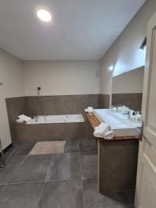 een badkamer met 2 wastafels en een bad bij Chambre d'hôtes Les Berges de l'Aude in Puicheric
