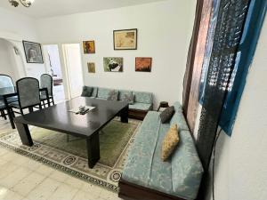 ein Wohnzimmer mit einem Sofa und einem Tisch in der Unterkunft Anis in Sousse