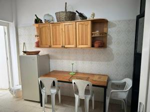 eine Küche mit einem Tisch und Stühlen sowie einem Kühlschrank in der Unterkunft Anis in Sousse