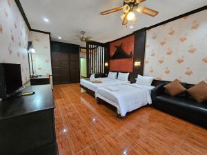- une chambre avec un grand lit et un canapé dans l'établissement Nanai 2 Residence Patong Phuket, à Patong Beach